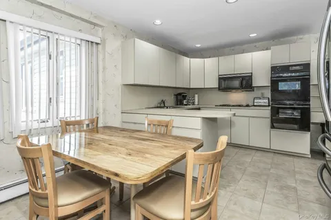 a dining table with chairs and kitchen view
