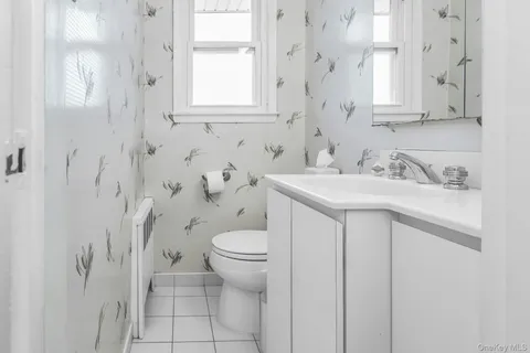 a bathroom with a sink toilet and window