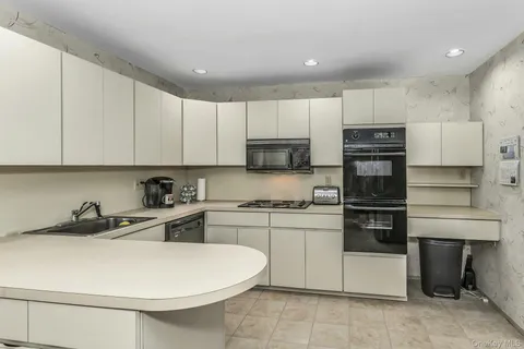 a kitchen with stainless steel appliances a stove a sink and a refrigerator