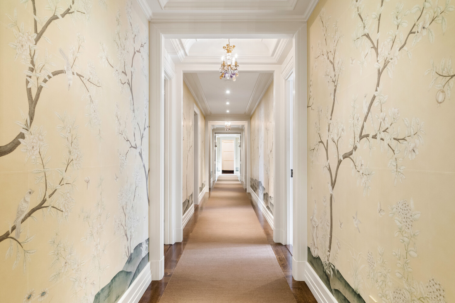 502 Park Avenue, Unit PH22 Manhattan, NY 10022 - Photo 10 of 19 a hallway with white walls and chandelier