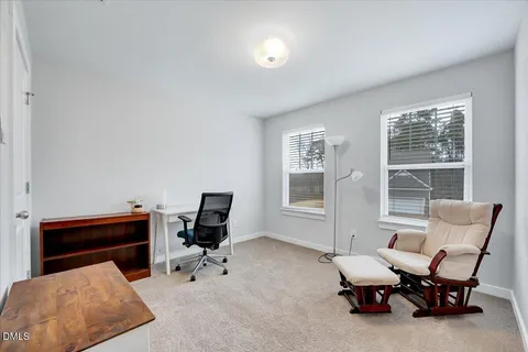 a view of a workspace with furniture and a window