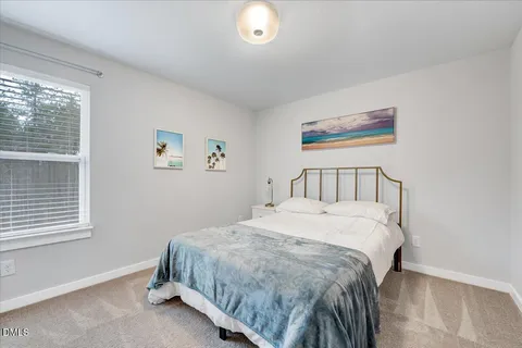 a bedroom with a bed and a painting on the wall