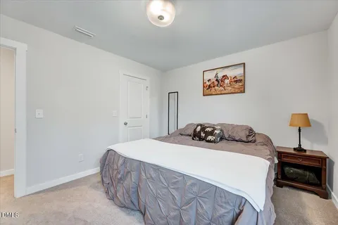 a bedroom with a bed and a lamp