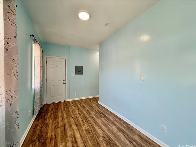 a view of a room with wooden floor and a bathroom