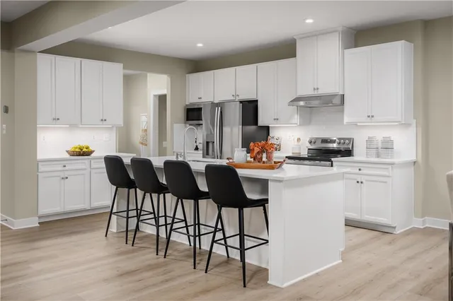 a kitchen with a dining table chairs and cabinets