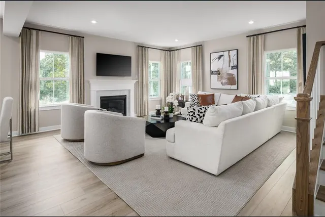 a living room with furniture a large window and a fireplace