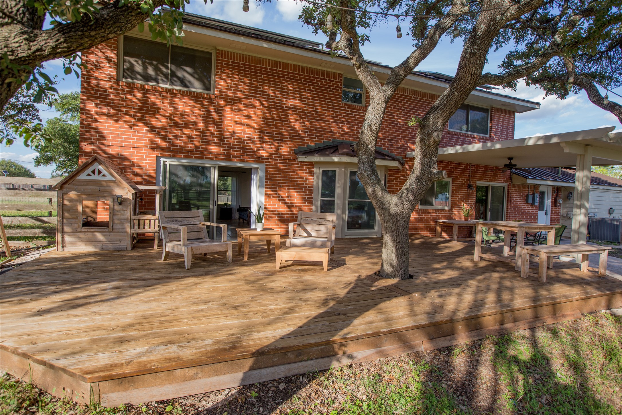 3517 Gattis School Road Round Rock, TX 78664 - Photo 9 of 16 A spacious wooden deck extends from a brick home, providing an ideal setting for outdoor gatherings.