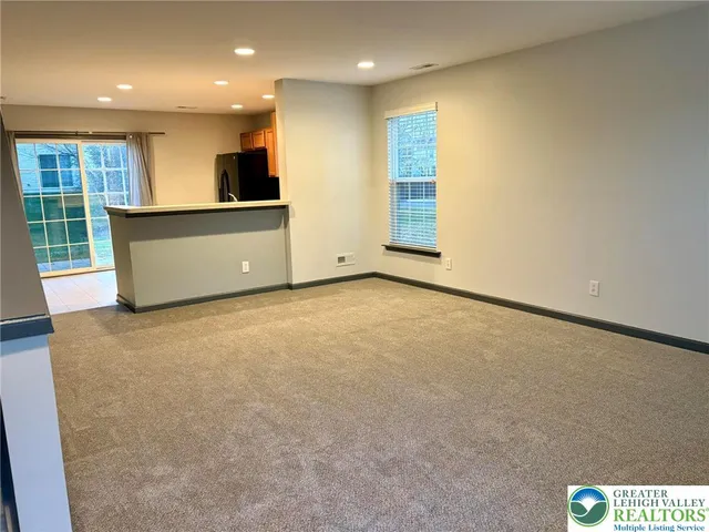 a view of an empty room with a kitchen