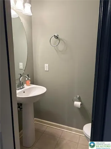 a bathroom with a sink a toilet and a mirror