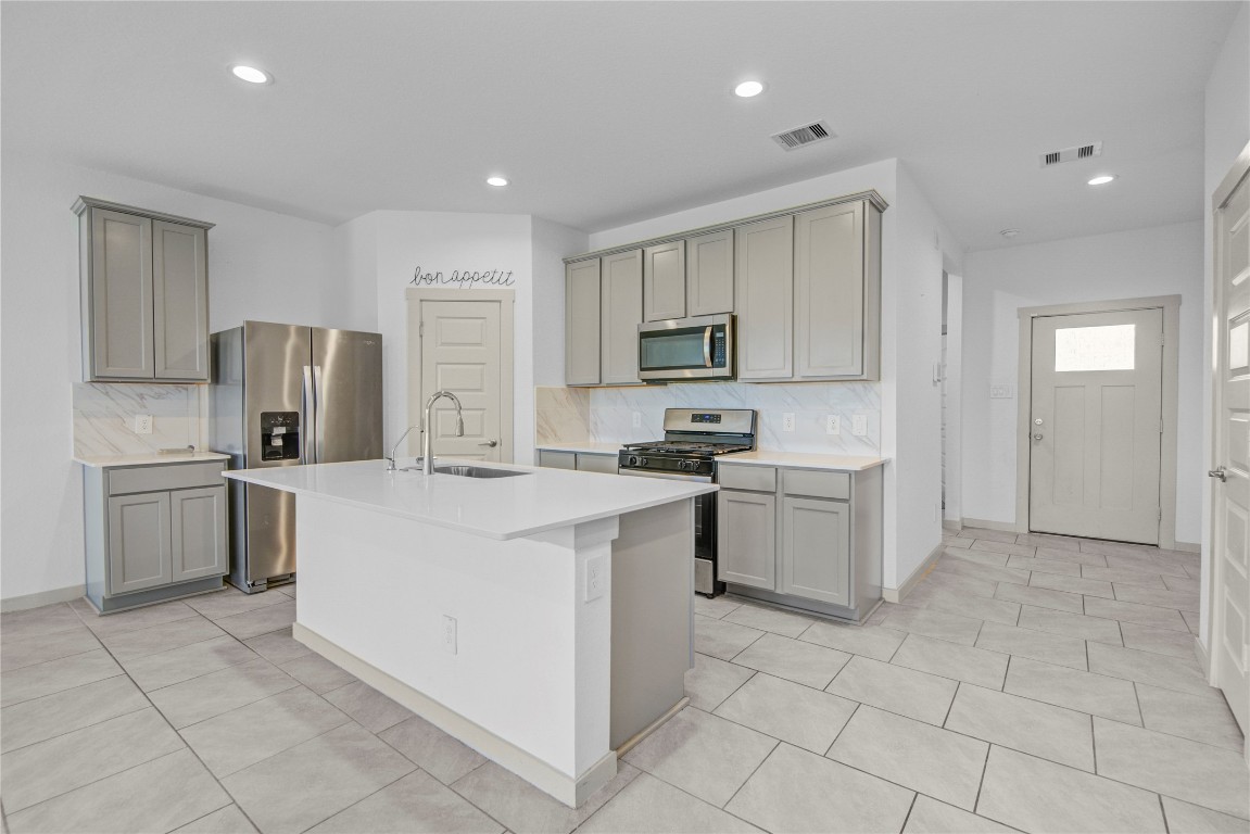 29847 Reagans Ranch Drive Katy, TX 77494 - Photo 6 of 36 a kitchen with a sink a counter top space stainless steel appliances and cabinets
