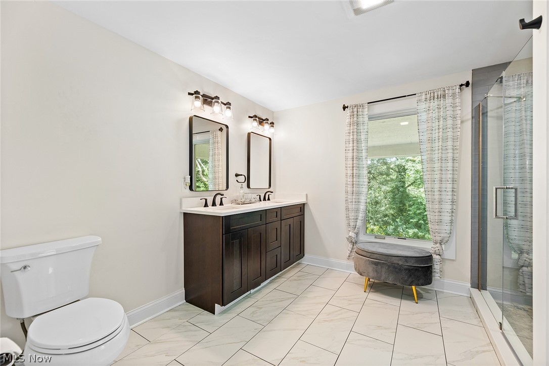 1375 North Revere Road Akron, OH 44333 - Photo 29 of 50 Dual vanity with dark wood-finish cabinetry, white countertop, and rectangular mirrors