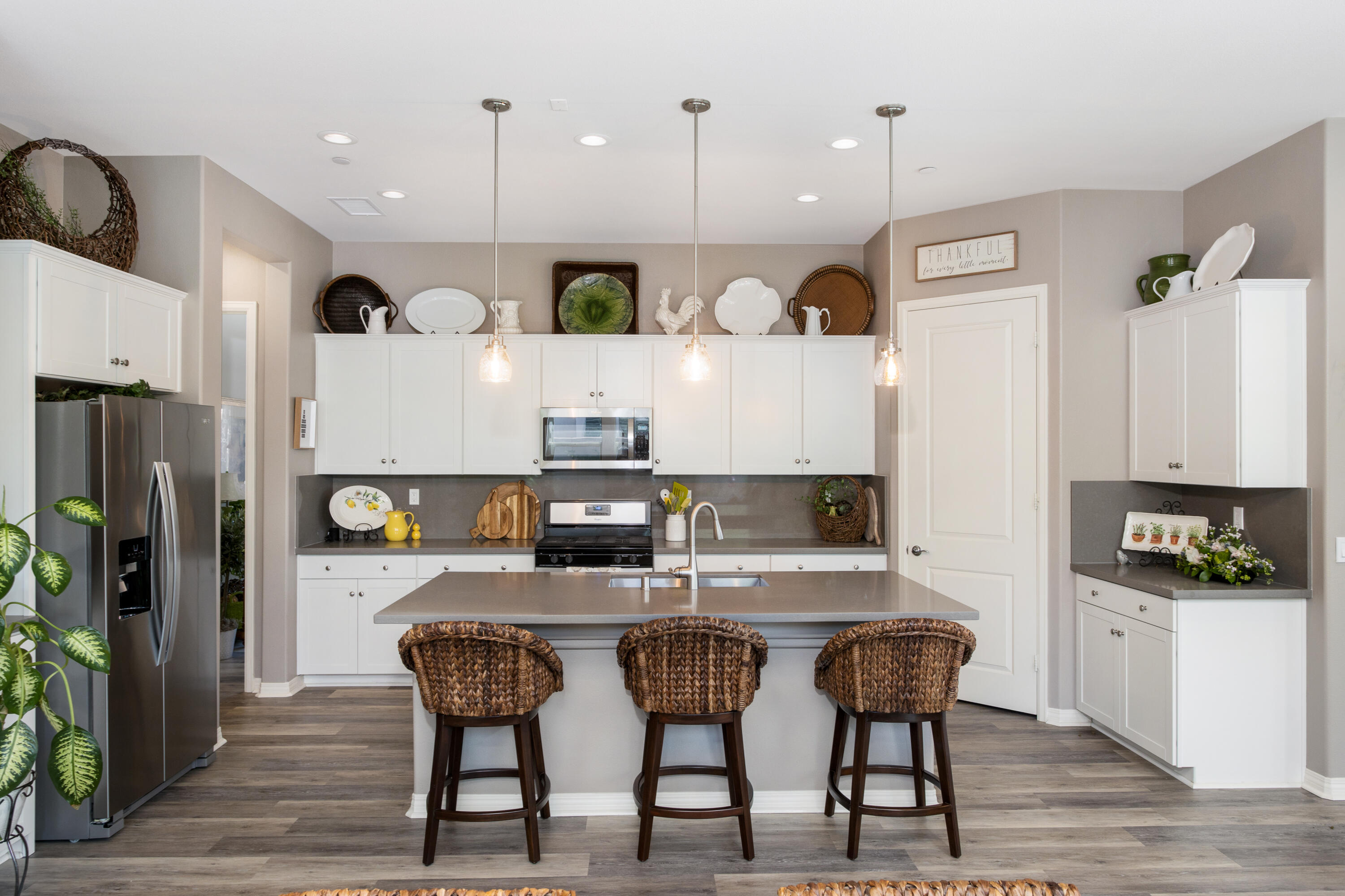 61 Syrah Rancho Mirage, CA 92270 - Photo 17 of 61 a kitchen with stainless steel appliances kitchen island granite countertop a refrigerator a stove a sink a dining table and chairs with wooden floor