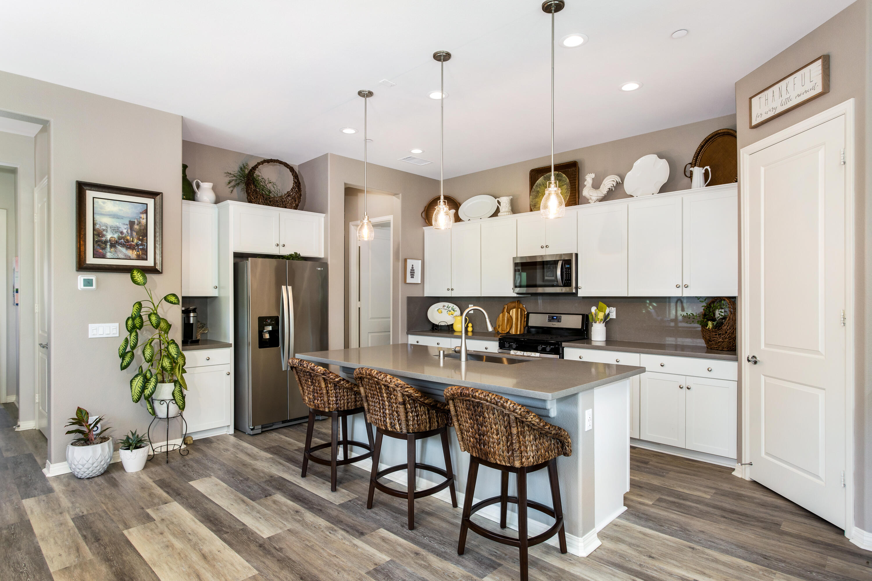 61 Syrah Rancho Mirage, CA 92270 - Photo 18 of 61 a kitchen with stainless steel appliances granite countertop a refrigerator a stove top oven a sink dishwasher and white cabinets with wooden floor