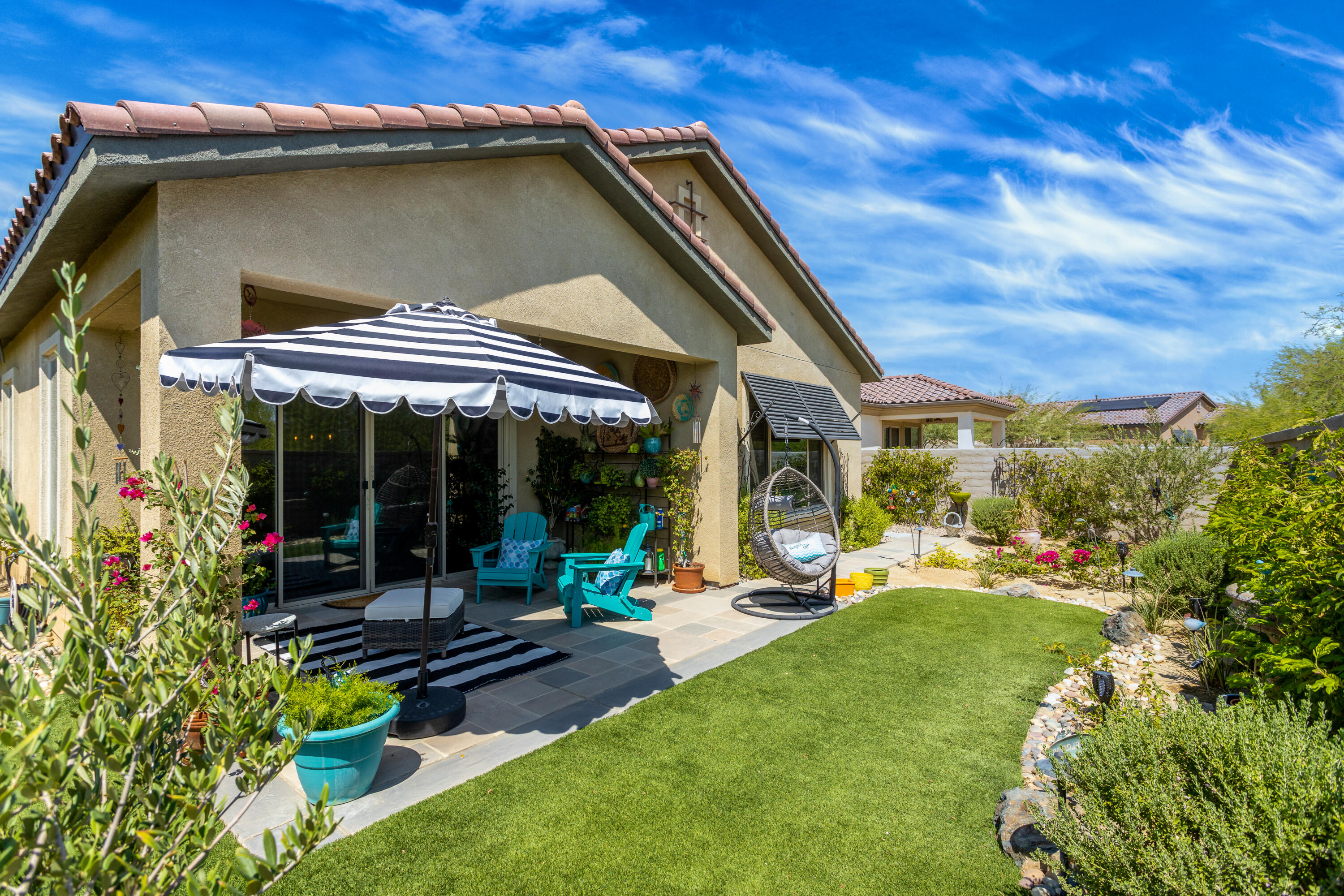 61 Syrah Rancho Mirage, CA 92270 - Photo 38 of 61 a view of a chair and tables in the patio with a backyard