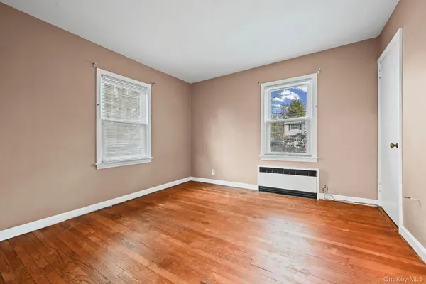 an empty room with windows and ceiling fan
