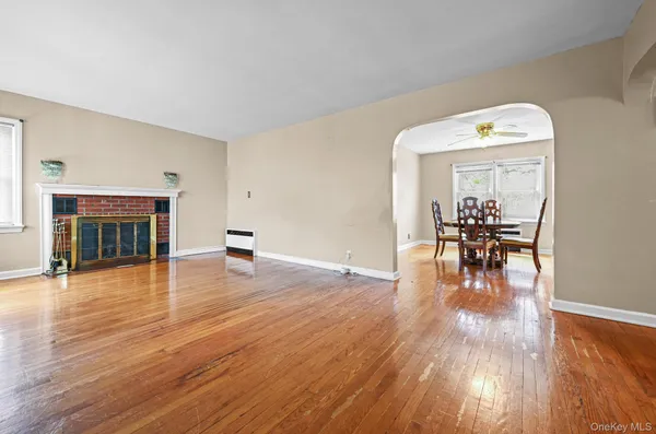 a view of a livingroom with furniture wooden floor fireplace and a window