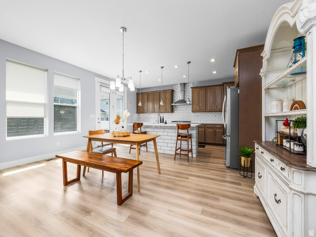 877 South Yarrow Drive Mapleton, UT 84664 - Photo 5 of 46 Open-concept living space featuring wood-finish flooring, a contemporary kitchen with a subway tile backsplash, stainless steel appliances, and dark wood cabinetry
