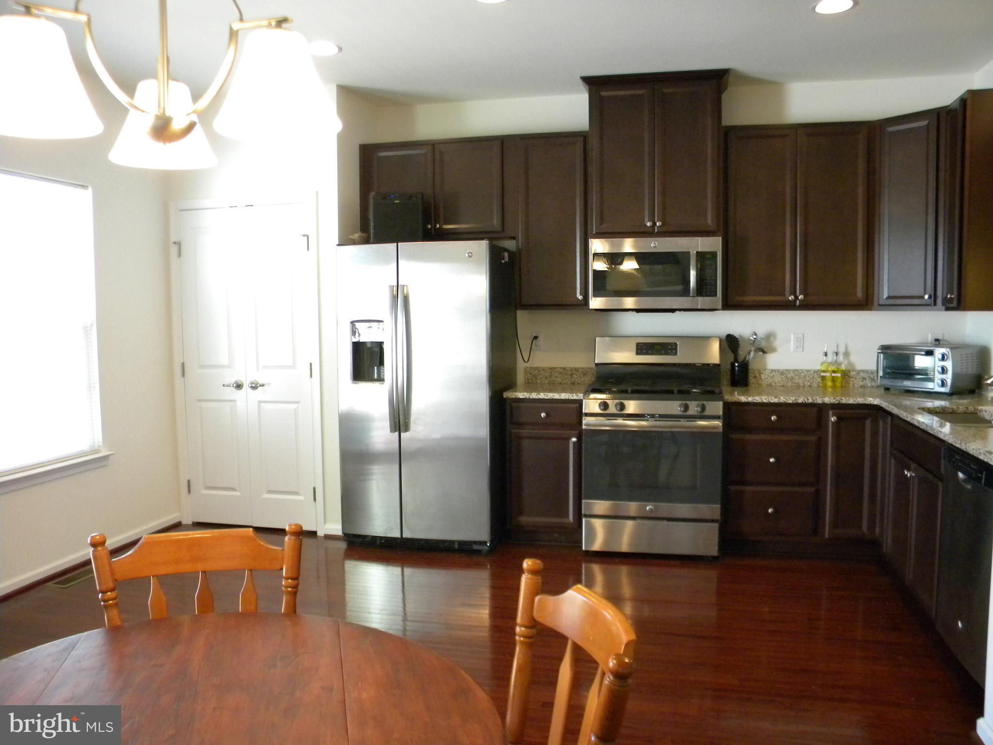 652 East Chestnut Street Souderton, PA 18964 - Photo 8 of 20 a kitchen with stainless steel appliances a refrigerator a stove a sink cabinets and a wooden floor