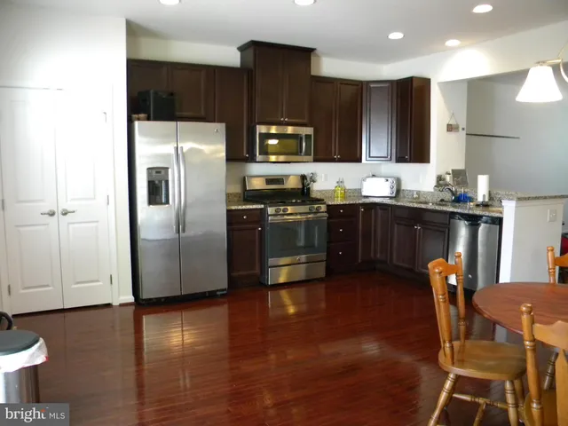 a kitchen with stainless steel appliances granite countertop a refrigerator a stove top oven a sink and dishwasher