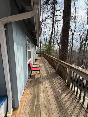 a balcony with wooden floor and trees