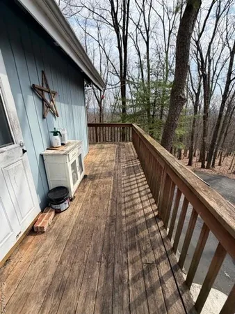 a view of balcony with wooden floor and fence and a pot