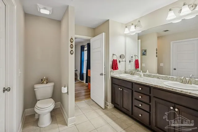 a spacious bathroom with a toilet sink and mirror