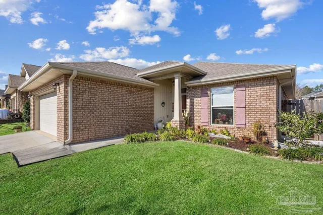 a front view of a house with a garden and yard