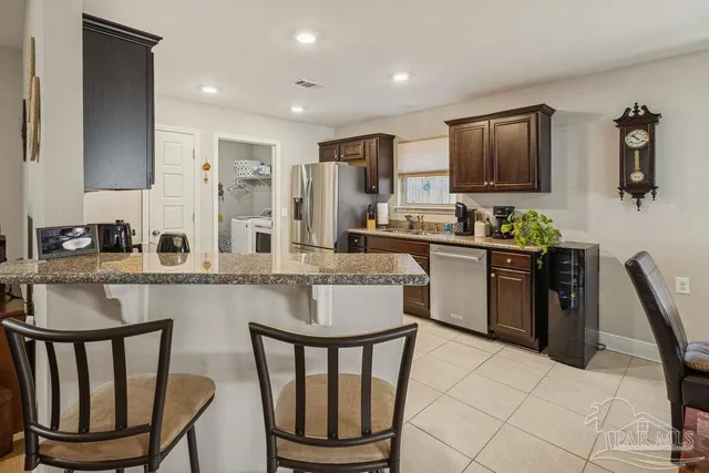 a kitchen with stainless steel appliances granite countertop a stove a sink dishwasher a stove a microwave a dining table and chairs