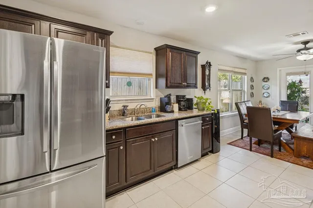 a kitchen with stainless steel appliances granite countertop a refrigerator and a stove top oven