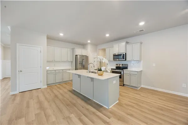 a kitchen with white cabinets and stainless steel appliances