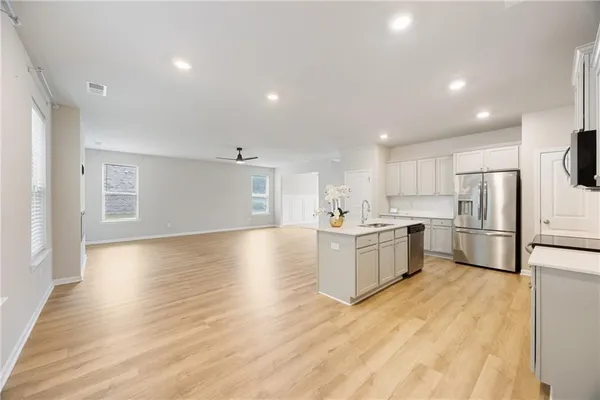 a kitchen with a refrigerator and a stove top oven