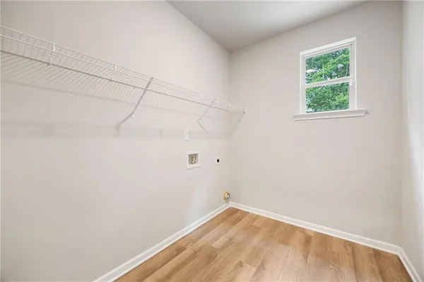 a view of a small space with wooden floor and a window