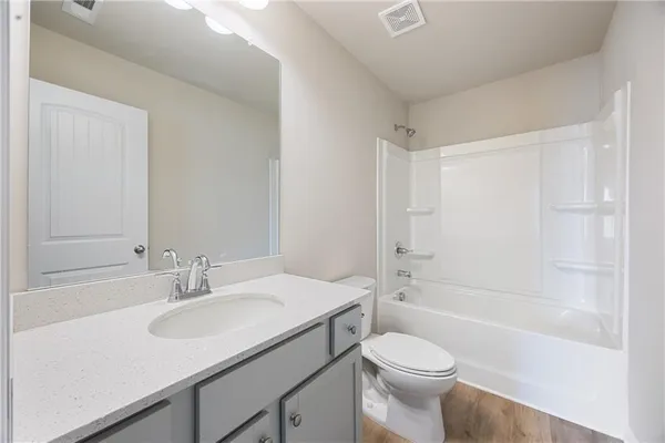a bathroom with a sink toilet vanity and shower
