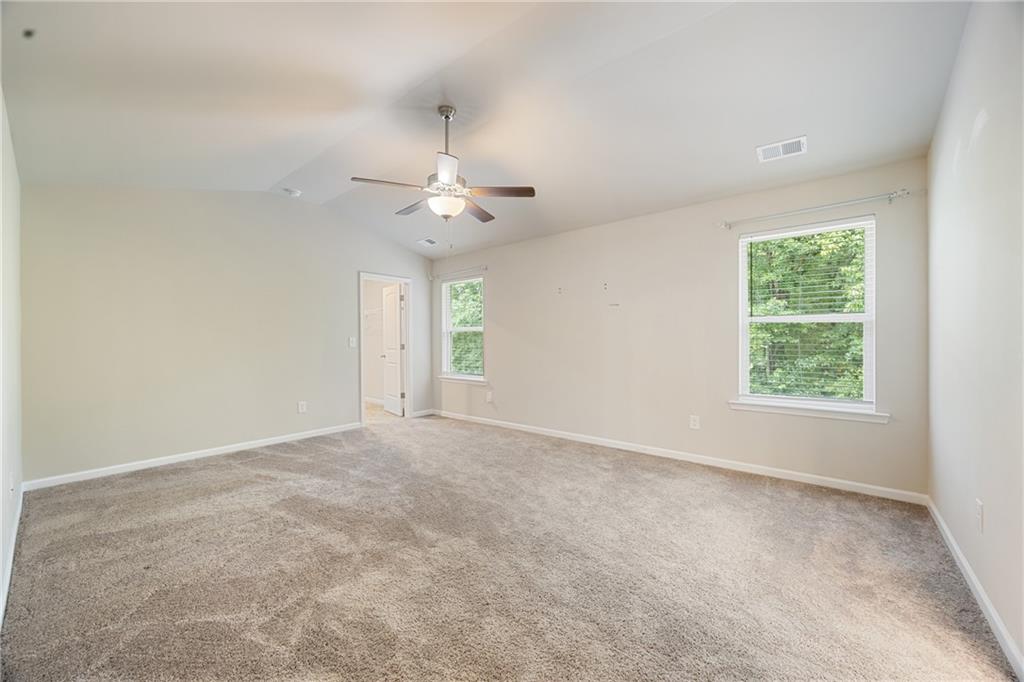 116 Cabin Way Hampton, GA 30228 - Photo 21 of 32 an empty room with a chandelier fan and windows