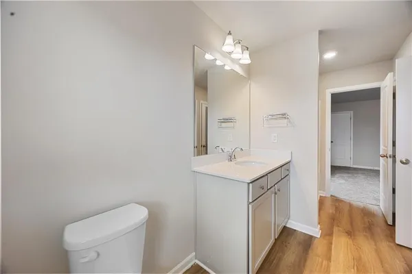 a bathroom with a toilet a sink a vanity and mirror