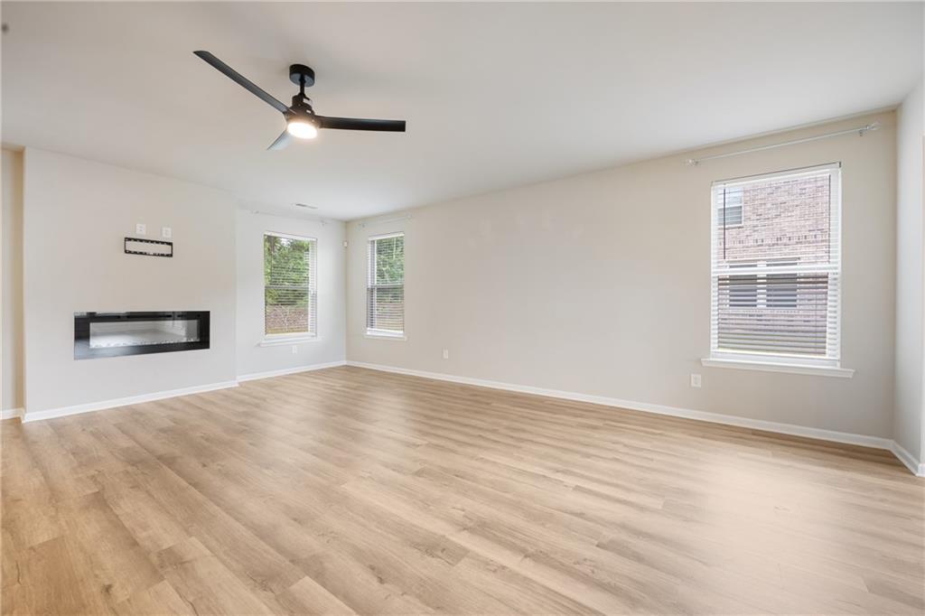 116 Cabin Way Hampton, GA 30228 - Photo 8 of 32 a view of an empty room with a window and wooden floor