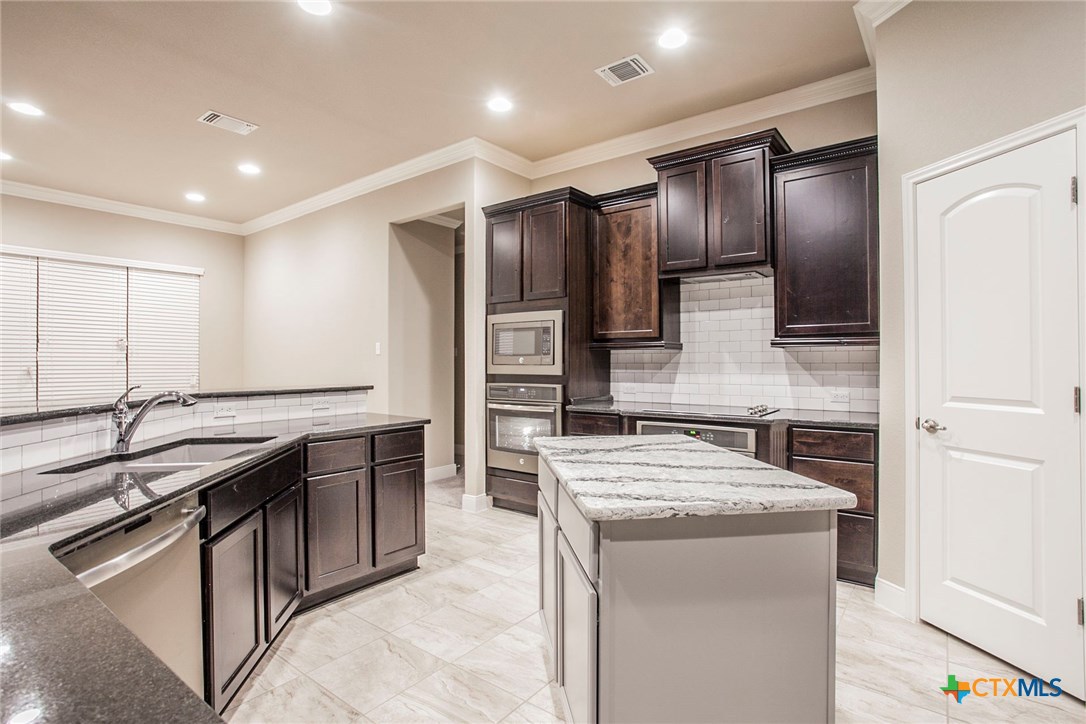 549 Wills Point Way Belton, TX 76513 - Photo 4 of 31 a kitchen with stainless steel appliances granite countertop a sink stove and refrigerator