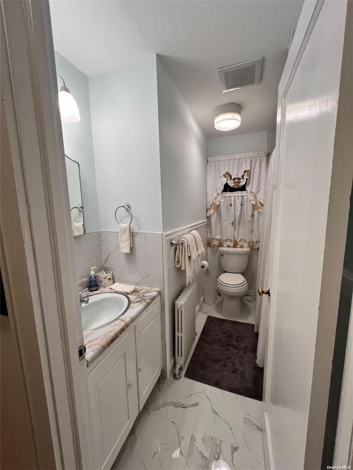 5 Lynncliff Road Hampton Bays, NY 11946 - Photo 16 of 31 a bathroom with a double vanity sink and mirror