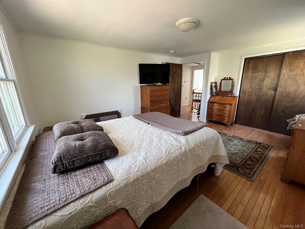 5 Lynncliff Road Hampton Bays, NY 11946 - Photo 22 of 31 a bedroom with a bed flat screen tv and window