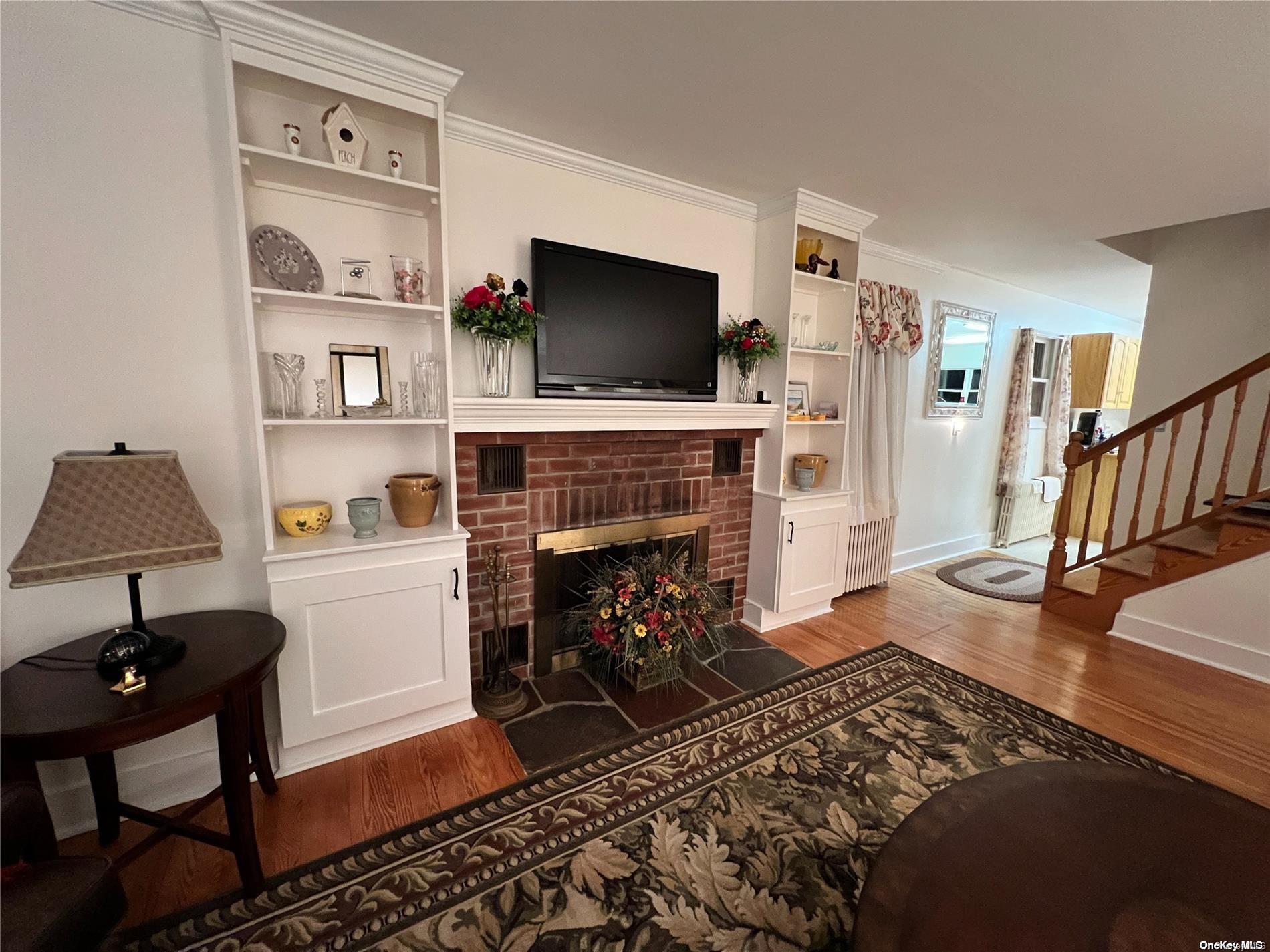 5 Lynncliff Road Hampton Bays, NY 11946 - Photo 3 of 31 a living room with furniture and a fireplace
