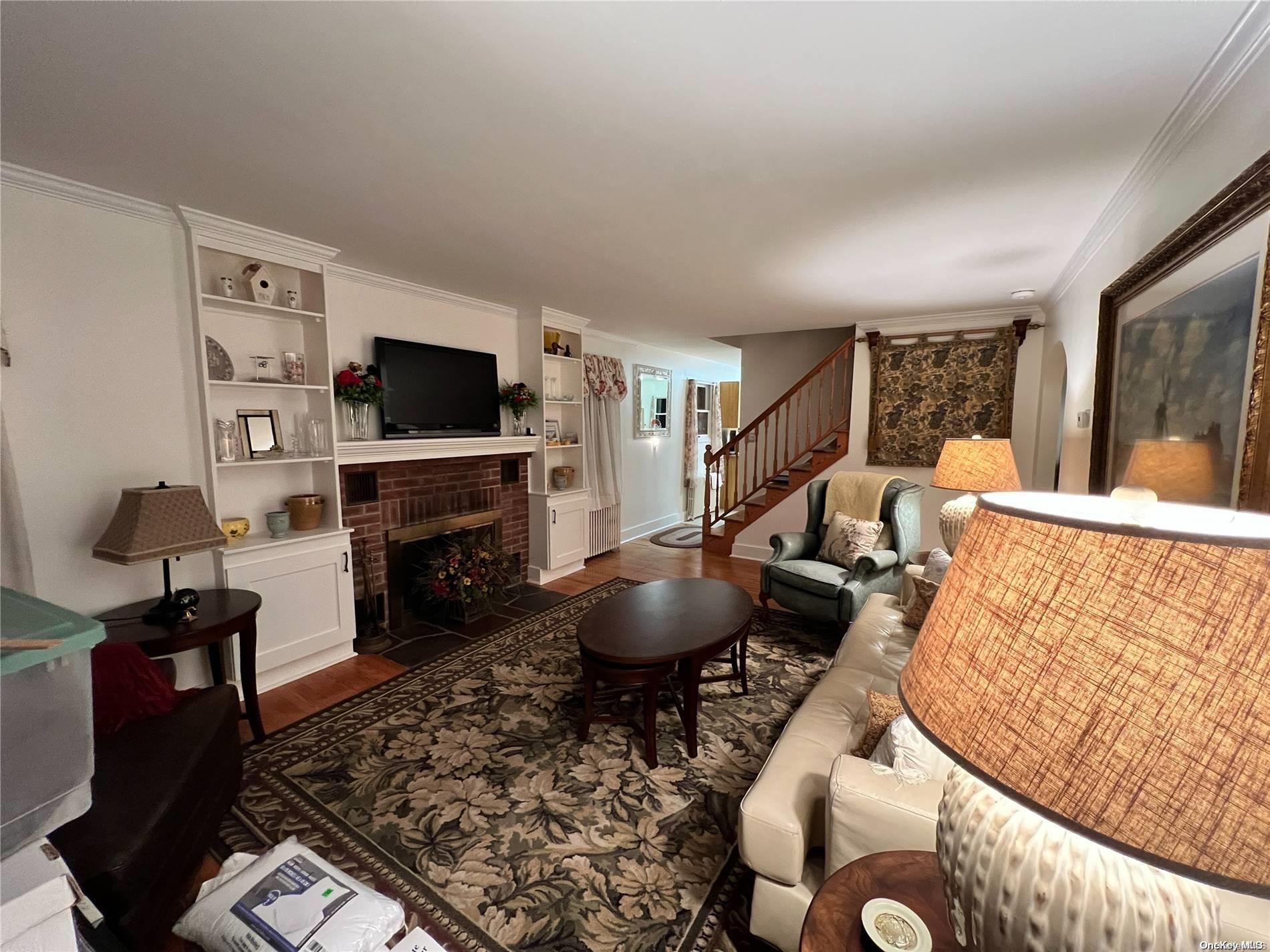 5 Lynncliff Road Hampton Bays, NY 11946 - Photo 4 of 31 a living room with furniture a flat screen tv and a fireplace