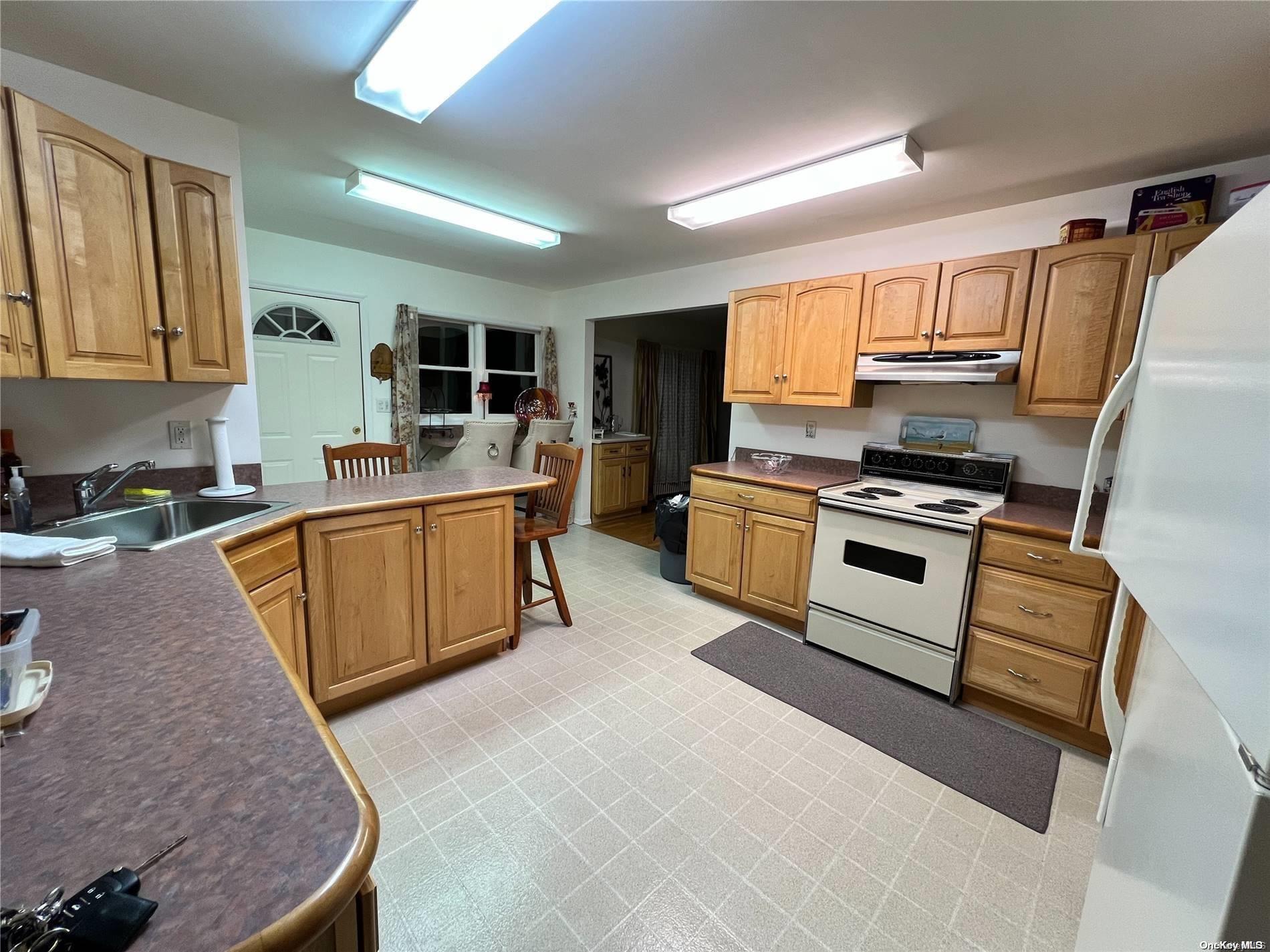 5 Lynncliff Road Hampton Bays, NY 11946 - Photo 10 of 31 a kitchen with stainless steel appliances granite countertop a stove a sink and a refrigerator
