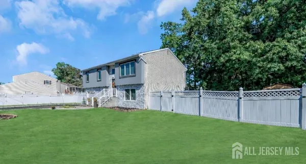 a view of house with backyard and a garden