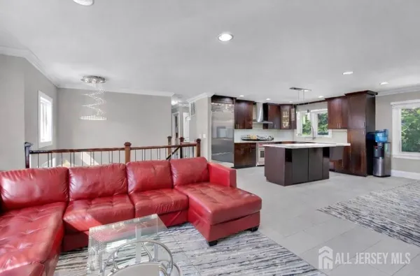 a living room with stainless steel appliances furniture and a kitchen view