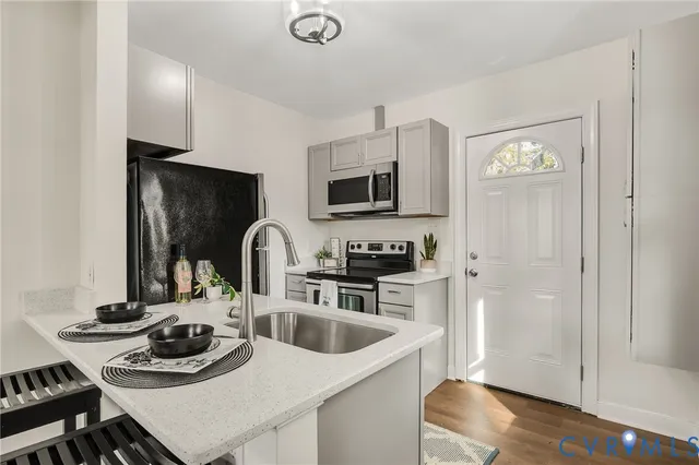 a kitchen with a sink a stove and cabinets