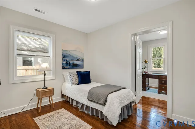 a bedroom with a bed table and a window