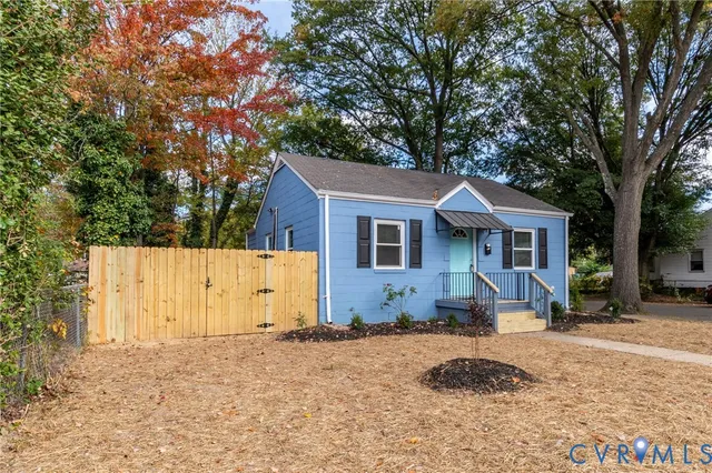 a view of a house with backyard and trees