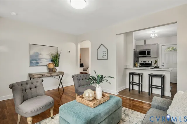 a living room with furniture and a view of kitchen