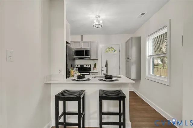 a kitchen with kitchen island a stove a sink and a microwave
