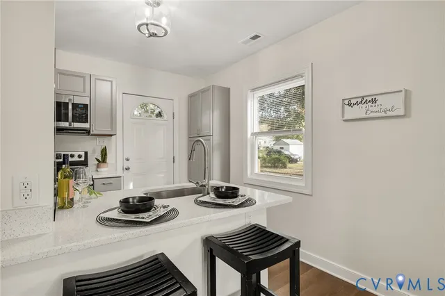 a kitchen with a sink a stove and white cabinets